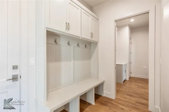 a view of an empty room with wooden floor and cabinet