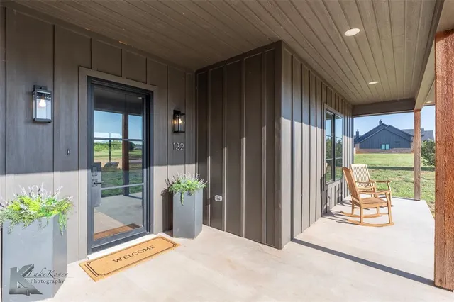 a view of a porch with chairs and potted plants