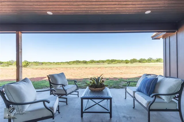 a living room with furniture and a floor to ceiling window