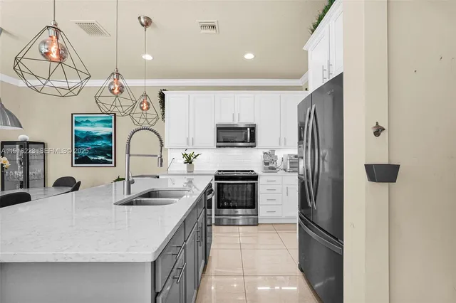 a kitchen with stainless steel appliances granite countertop a sink and a refrigerator