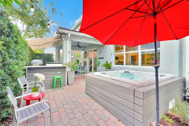 a patio with a table and chairs under an umbrella