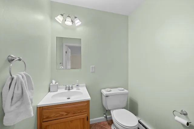 a bathroom with a toilet sink vanity and mirror