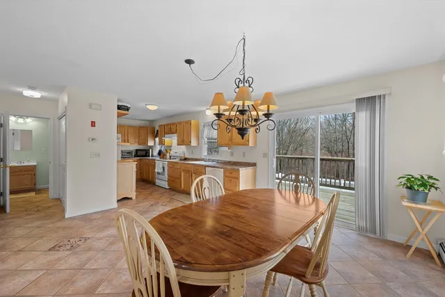 a view of a dining room and livingroom with furniture wooden floor a chandelier
