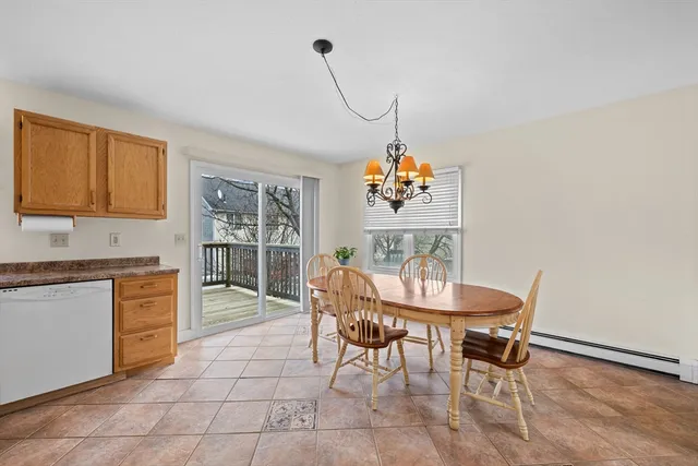 a dining room filled chandelier and kitchen view