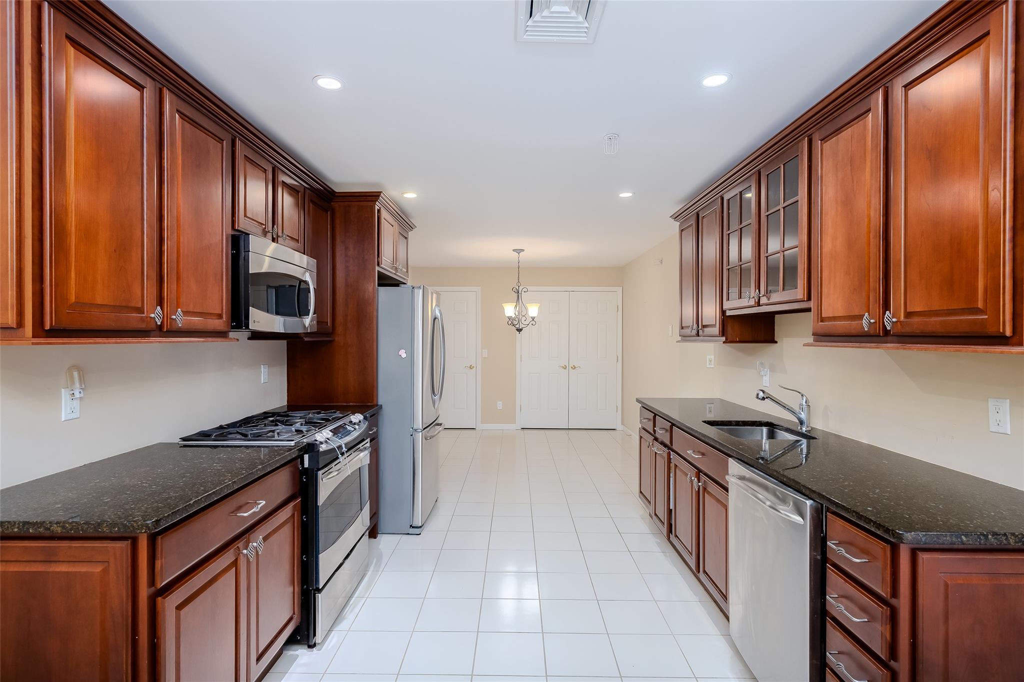 166 Ira Road Mount Sinai, NY 11766 - Photo 10 of 37 a kitchen with stainless steel appliances granite countertop a stove a sink and a microwave