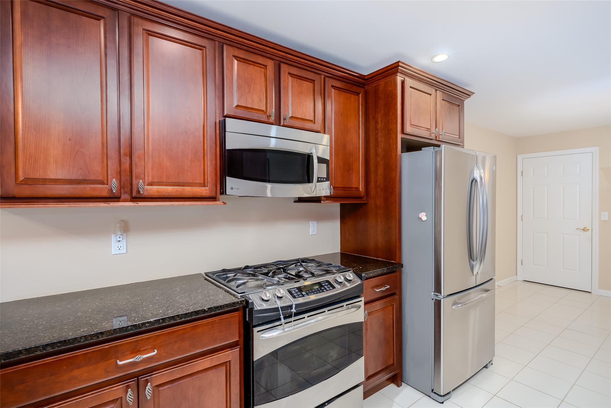 166 Ira Road Mount Sinai, NY 11766 - Photo 11 of 37 a kitchen with stainless steel appliances granite countertop a refrigerator stove and cabinets