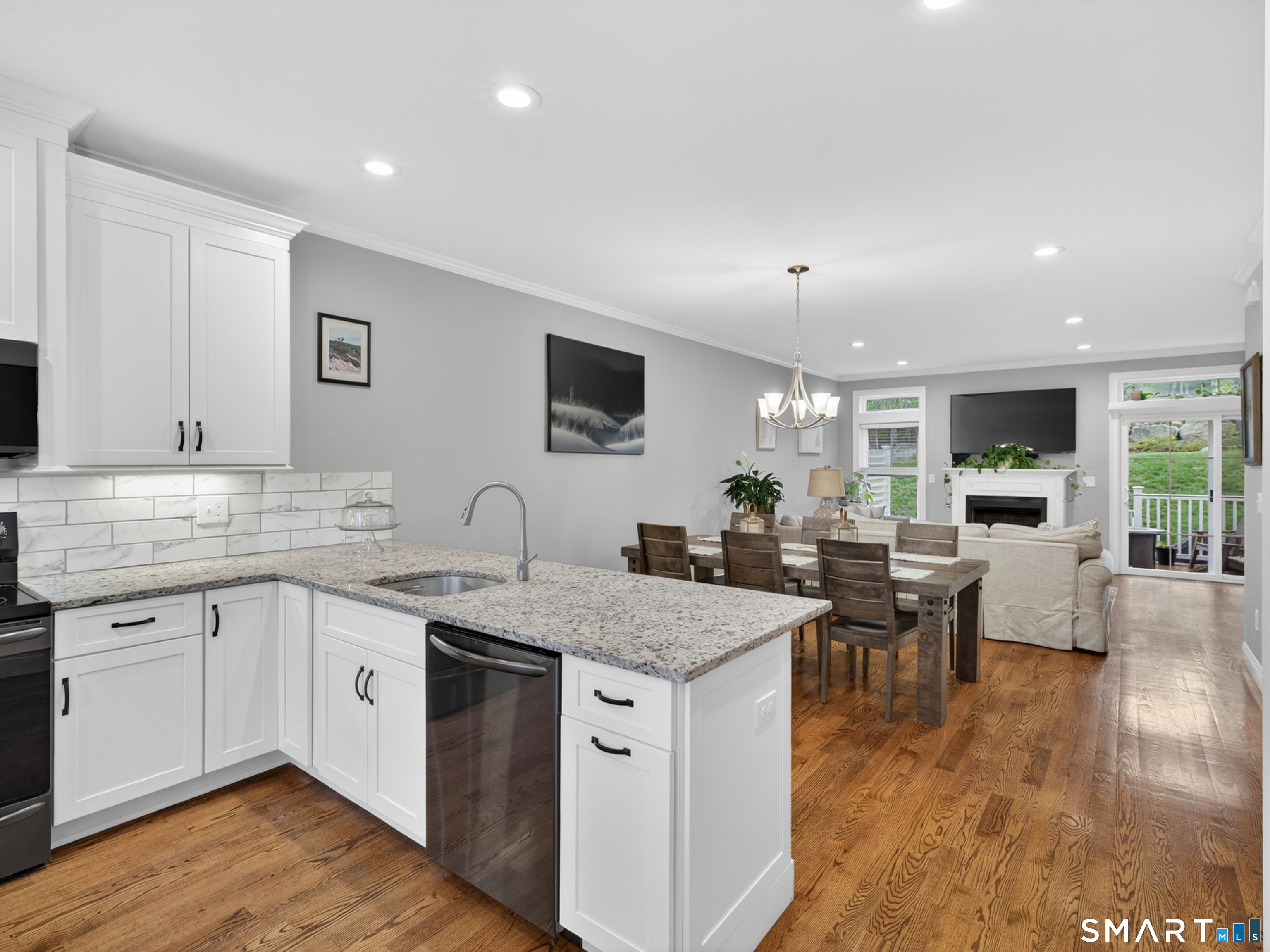 34 Village Crossing, Unit 34 Niantic, CT 06357 - Photo 15 of 38 a open kitchen with stainless steel appliances granite countertop a sink and dining table with wooden floor