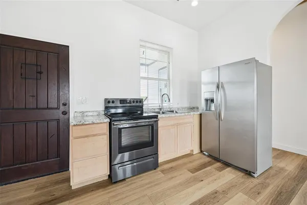 a kitchen with stainless steel appliances granite countertop a refrigerator and a stove top oven