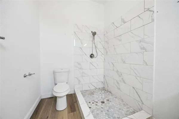 a white toilet sitting next to a shower