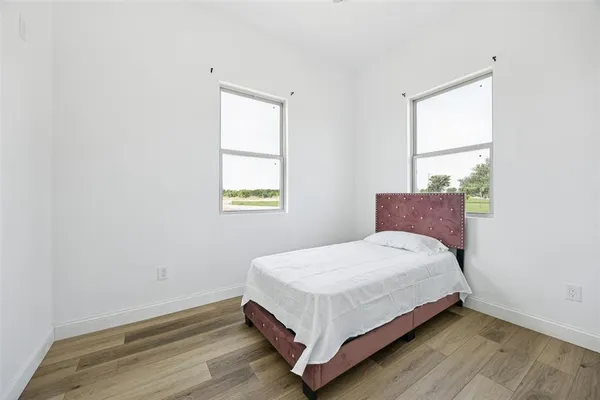 a bed sitting in a bedroom next to a window
