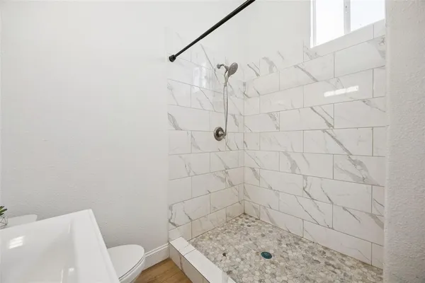 a bathroom with a sink a toilet and shower