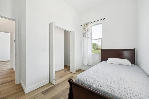 a bedroom with a bed and wooden floor