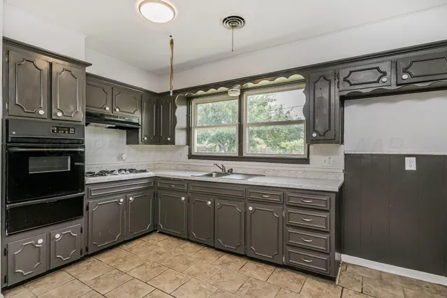a kitchen with stainless steel appliances granite countertop a refrigerator and a sink