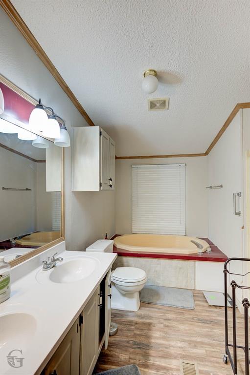 8839 Sebastian Road Keithville, LA 71047 - Photo 40 of 40 Dual-sink vanity with a light-toned countertop, wood-finish flooring, built-in soaking tub, and window with blinds