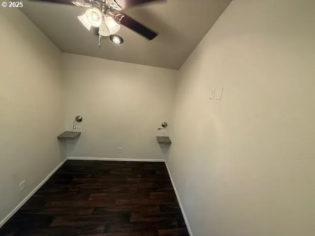 a view of a livingroom with wooden floor and a ceiling fan