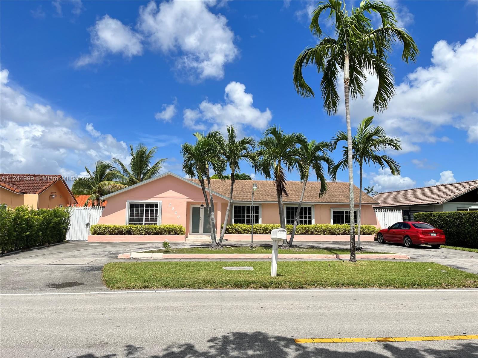 a palm tree sitting in front of a house with a yard