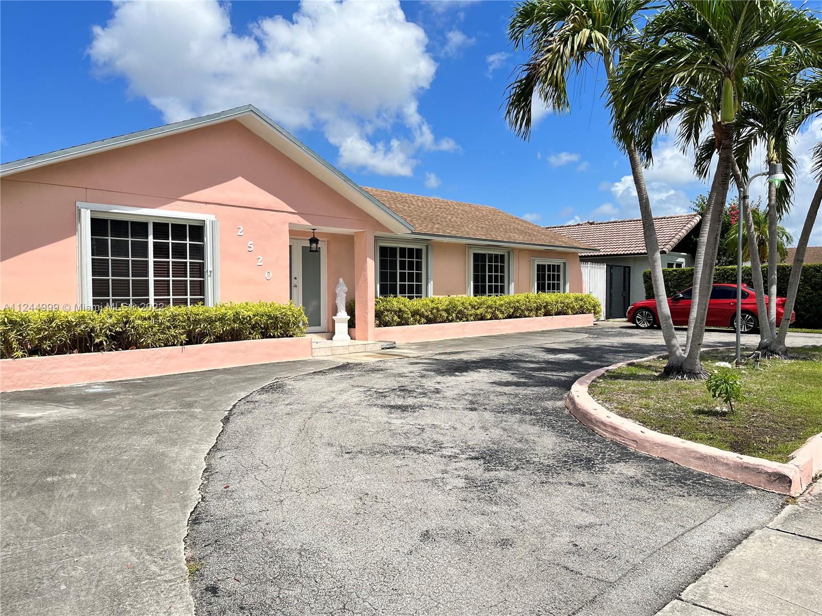 2520 Southwest 102nd Avenue Miami, FL 33165 - Photo 2 of 21 a front view of a house with a yard and trees