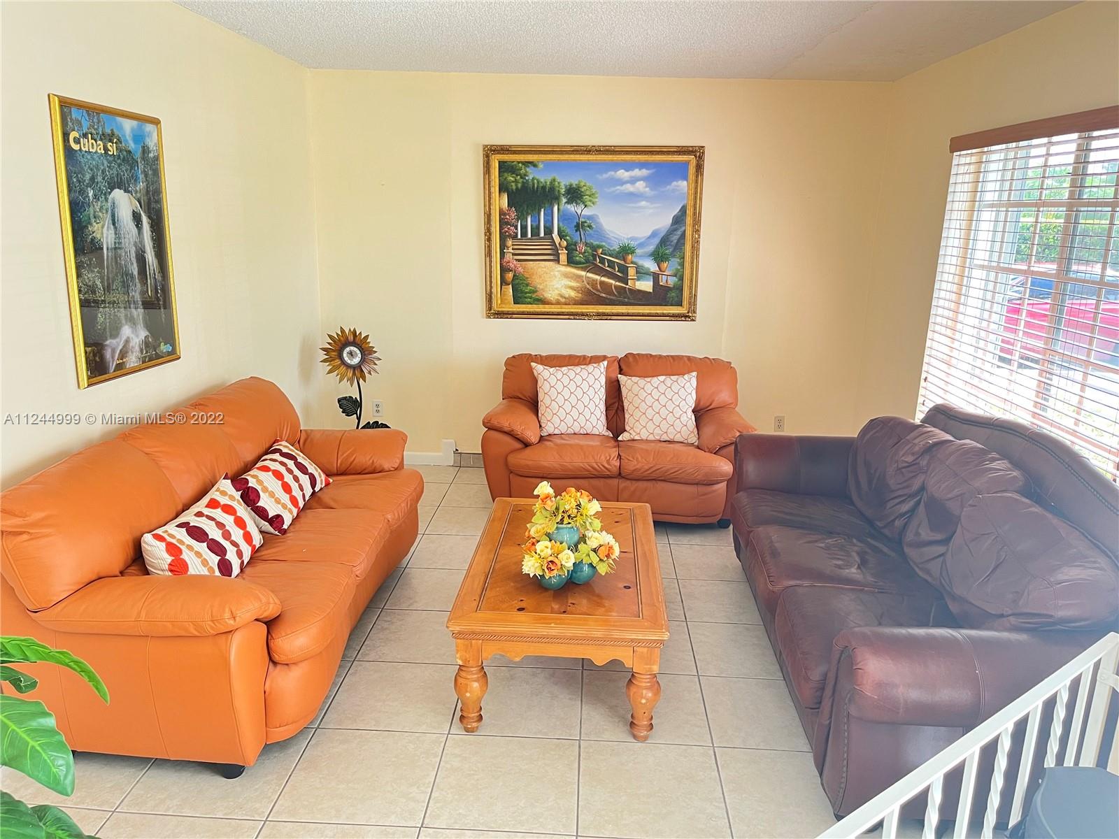 2520 Southwest 102nd Avenue Miami, FL 33165 - Photo 5 of 21 a living room with a couch and paintings on the wall
