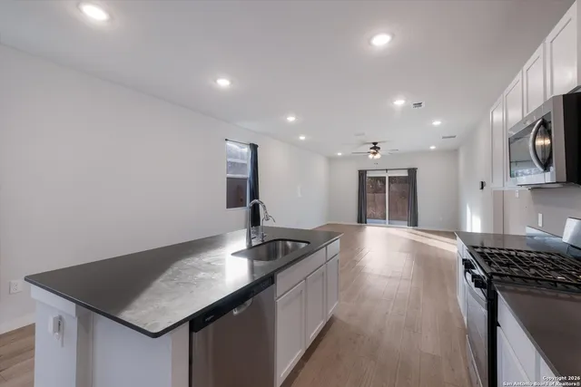 a kitchen with stainless steel appliances granite countertop a sink a stove and a refrigerator