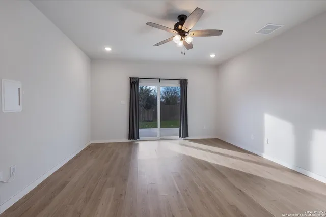 wooden floor in an empty room with a window