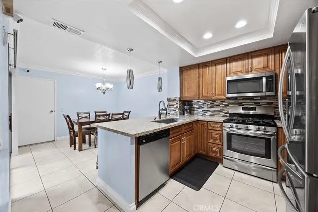 a kitchen with stainless steel appliances granite countertop a stove a sink and a microwave
