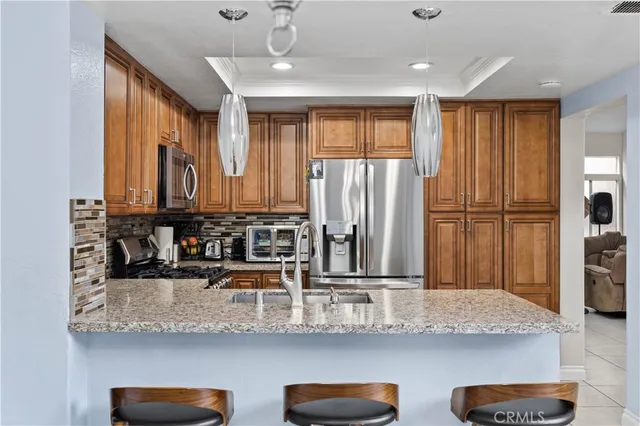 a kitchen with stainless steel appliances granite countertop a sink and a refrigerator