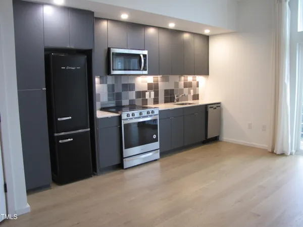 a kitchen with stainless steel appliances a sink stove and refrigerator