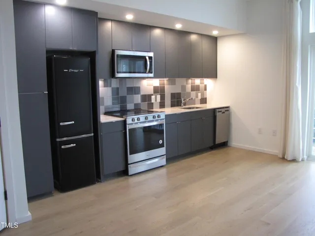 a kitchen with stainless steel appliances a sink stove and refrigerator