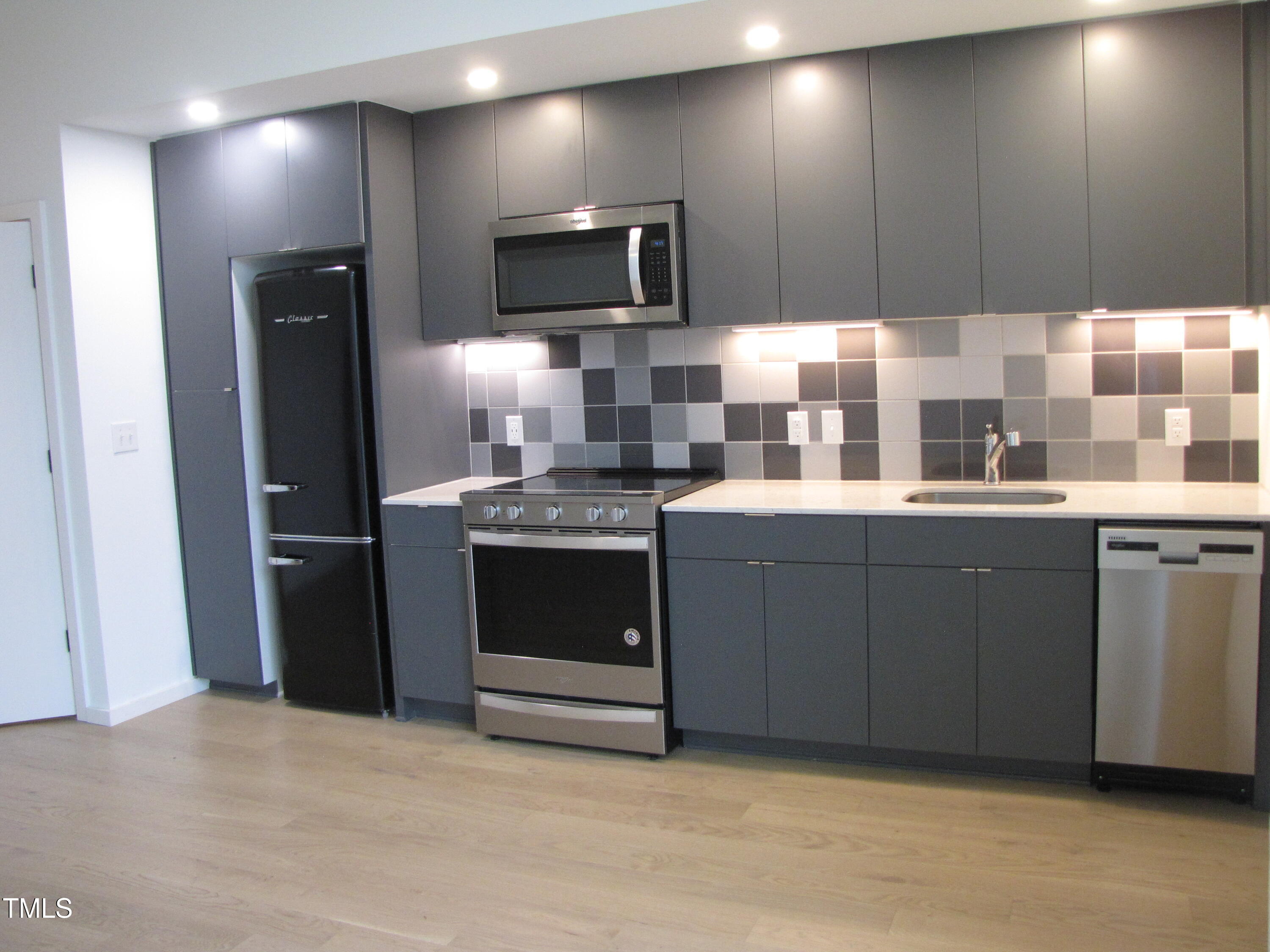 600 South Duke Street, Unit 23 Durham, NC 27701 - Photo 7 of 19 a kitchen with stainless steel appliances a sink stove and refrigerator