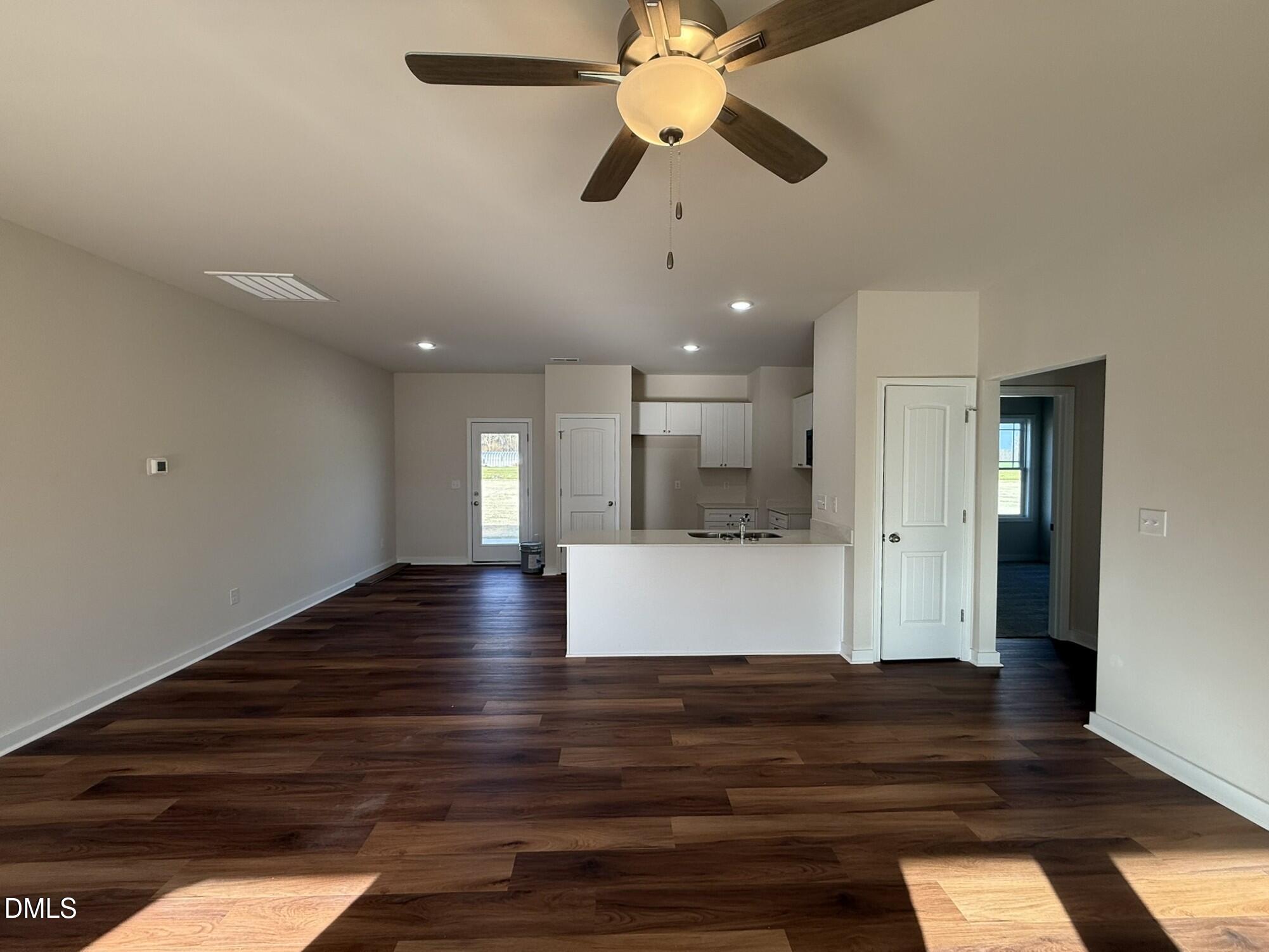 129 Jacobs Ridge Drive Four Oaks, NC 27524 - Photo 8 of 18 a view of an empty room with wooden floor and a ceiling fan