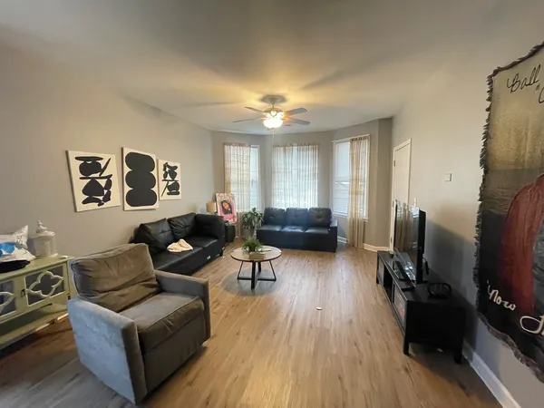 a living room with furniture a flat screen tv and a window
