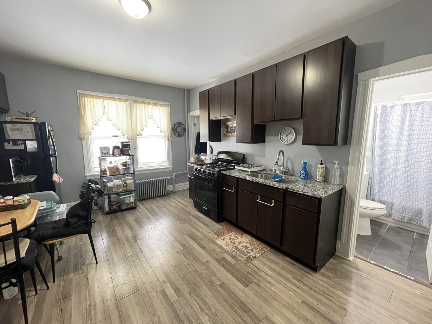 4155 West Roscoe Street Chicago, IL 60641 - Photo 8 of 11 a kitchen with stainless steel appliances granite countertop wooden cabinets a sink dishwasher a stove and a refrigerator with wooden floor