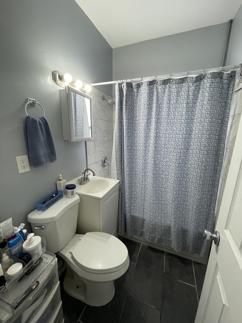 4155 West Roscoe Street Chicago, IL 60641 - Photo 9 of 11 a white toilet sitting next to a bathroom sink