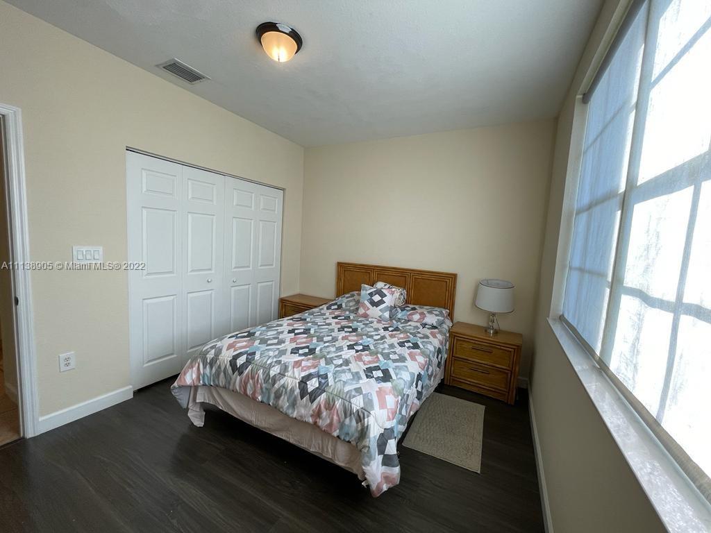 9323 Southwest 227th Street, Unit 75 Cutler Bay, FL 33190 - Photo 11 of 44 a bed sitting in a bedroom next to a window