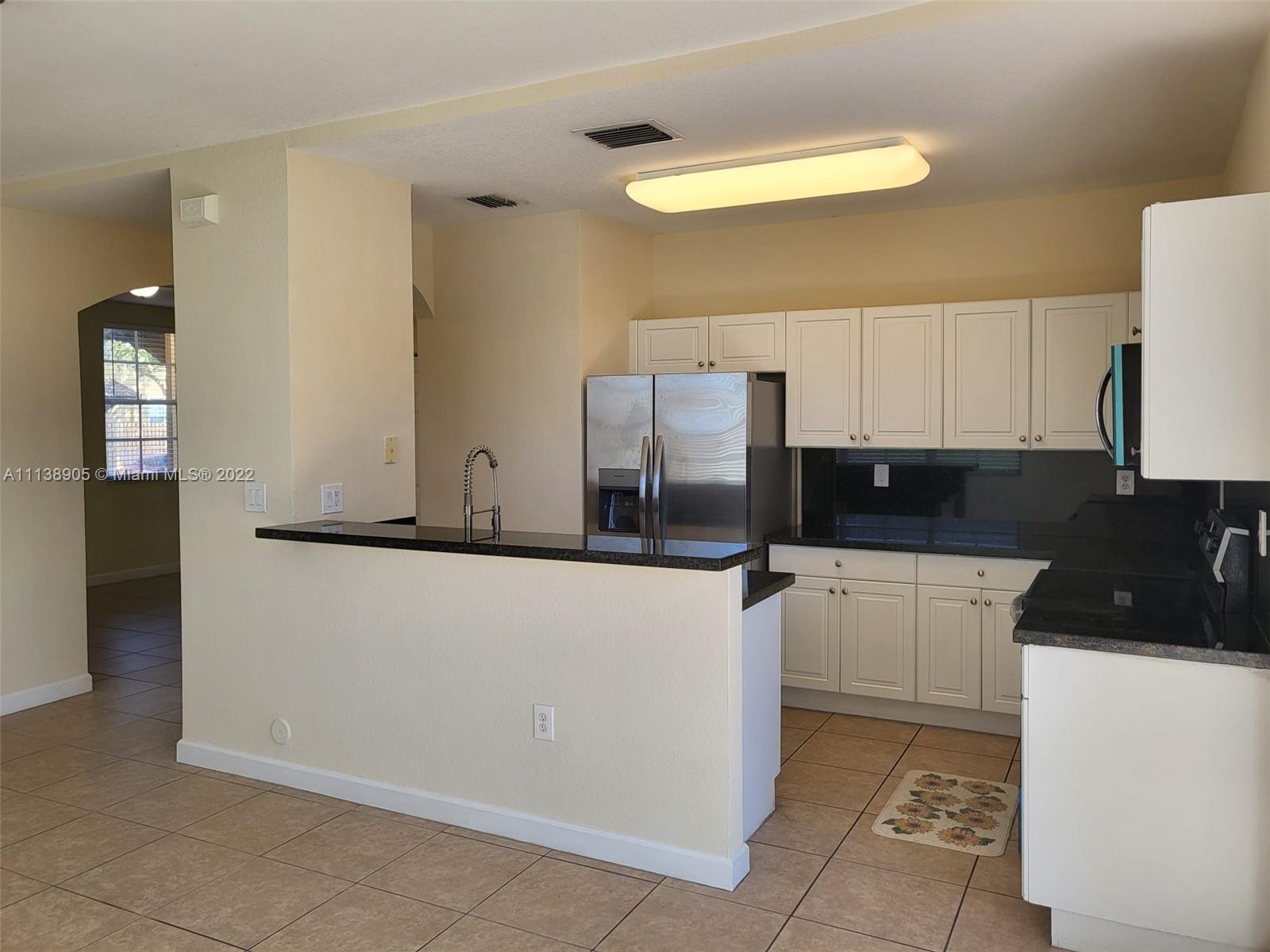 9323 Southwest 227th Street, Unit 75 Cutler Bay, FL 33190 - Photo 18 of 44 a kitchen with stainless steel appliances a refrigerator and a stove
