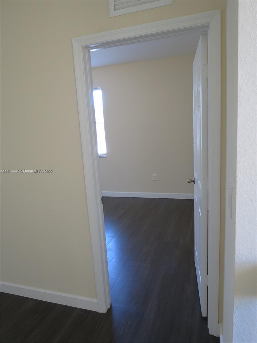 9323 Southwest 227th Street, Unit 75 Cutler Bay, FL 33190 - Photo 22 of 44 an empty room with wooden floor