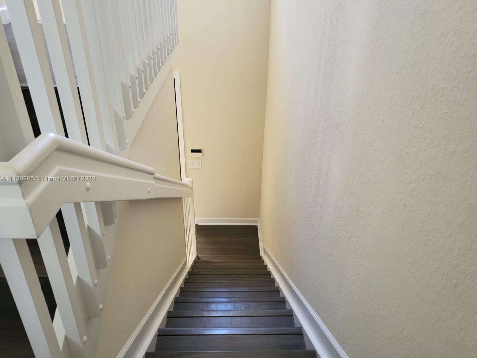 9323 Southwest 227th Street, Unit 75 Cutler Bay, FL 33190 - Photo 33 of 44 a view of staircase with wooden floor and white walls