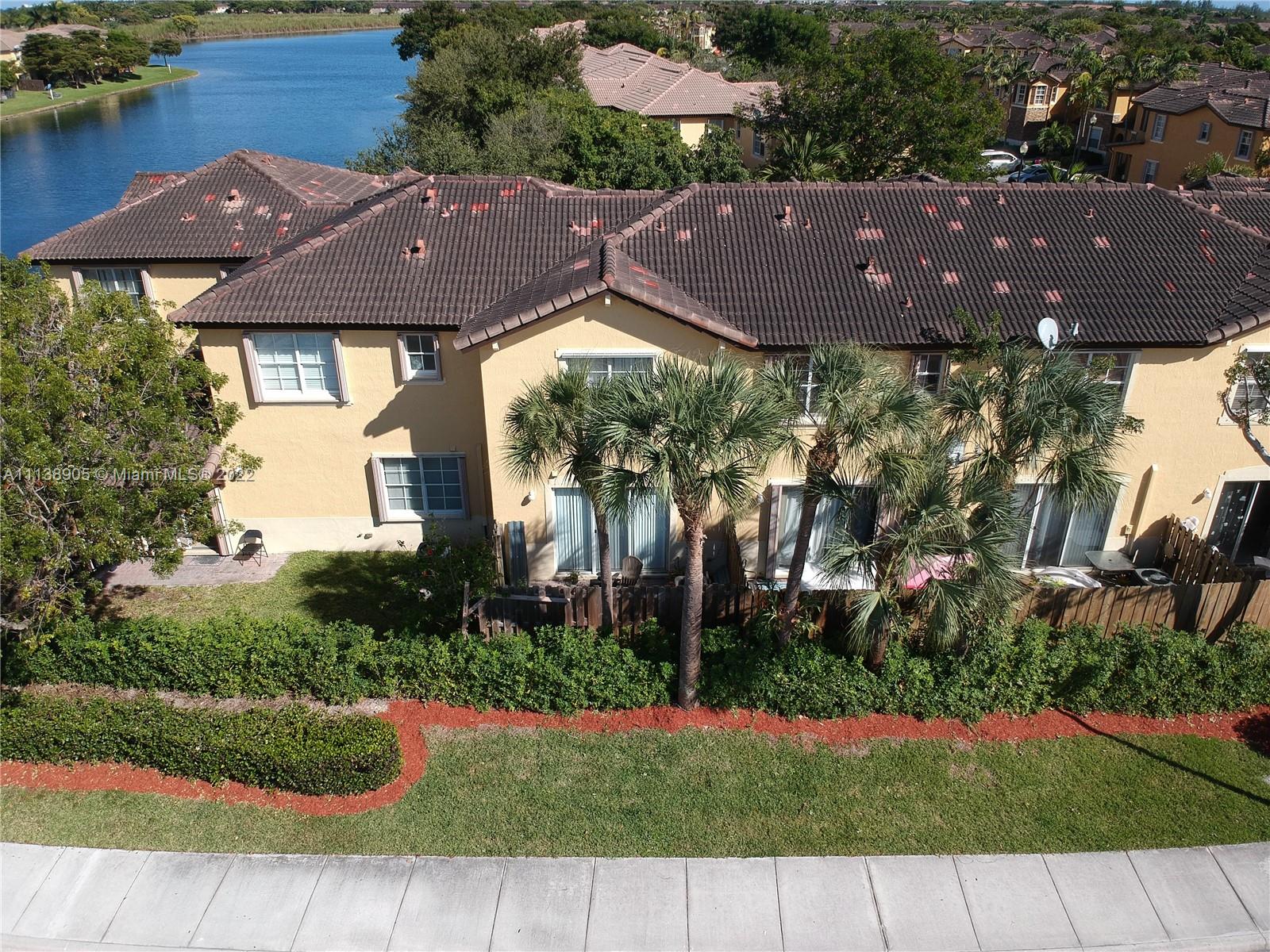 9323 Southwest 227th Street, Unit 75 Cutler Bay, FL 33190 - Photo 42 of 44 a view of house with a yard and a bench