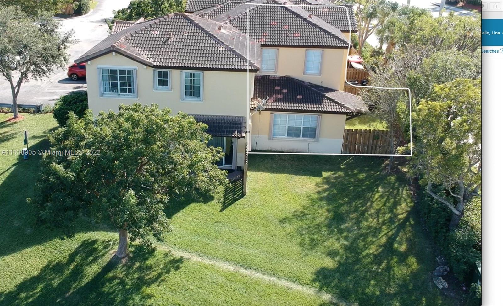 9323 Southwest 227th Street, Unit 75 Cutler Bay, FL 33190 - Photo 43 of 44 a front view of a house with a yard and trees