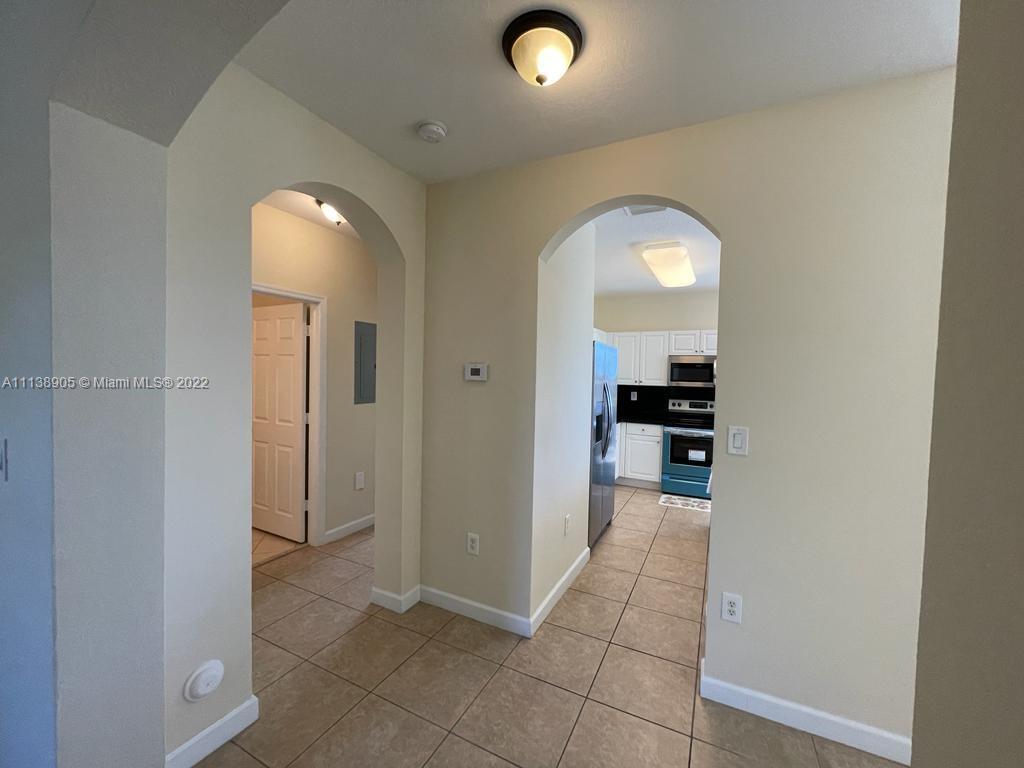 9323 Southwest 227th Street, Unit 75 Cutler Bay, FL 33190 - Photo 8 of 44 view of a hallway with wooden floor a bathroom and a sink