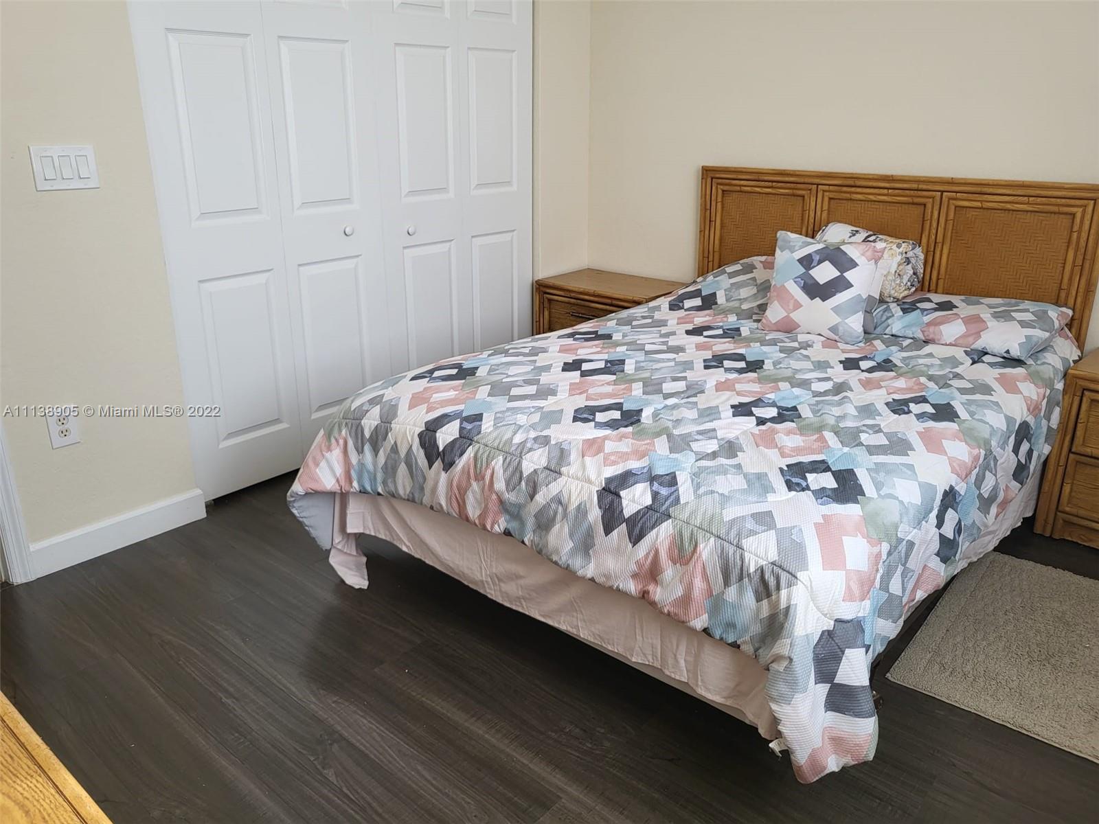 9323 Southwest 227th Street, Unit 75 Cutler Bay, FL 33190 - Photo 10 of 44 a bed sitting in a bedroom next to a cabinet