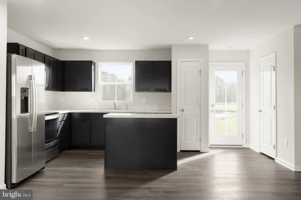 a kitchen with stainless steel appliances granite countertop a refrigerator and a stove top oven