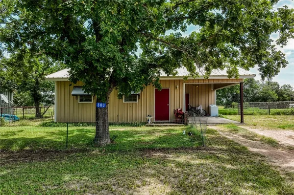 a view of a house with a yard and sitting area