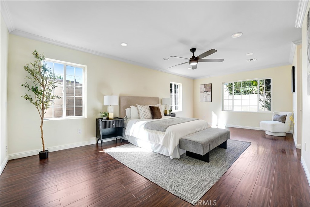 21323 Martin Street Carson, CA 90745 - Photo 13 of 21 a spacious bedroom with a large bed a chandelier and a couch