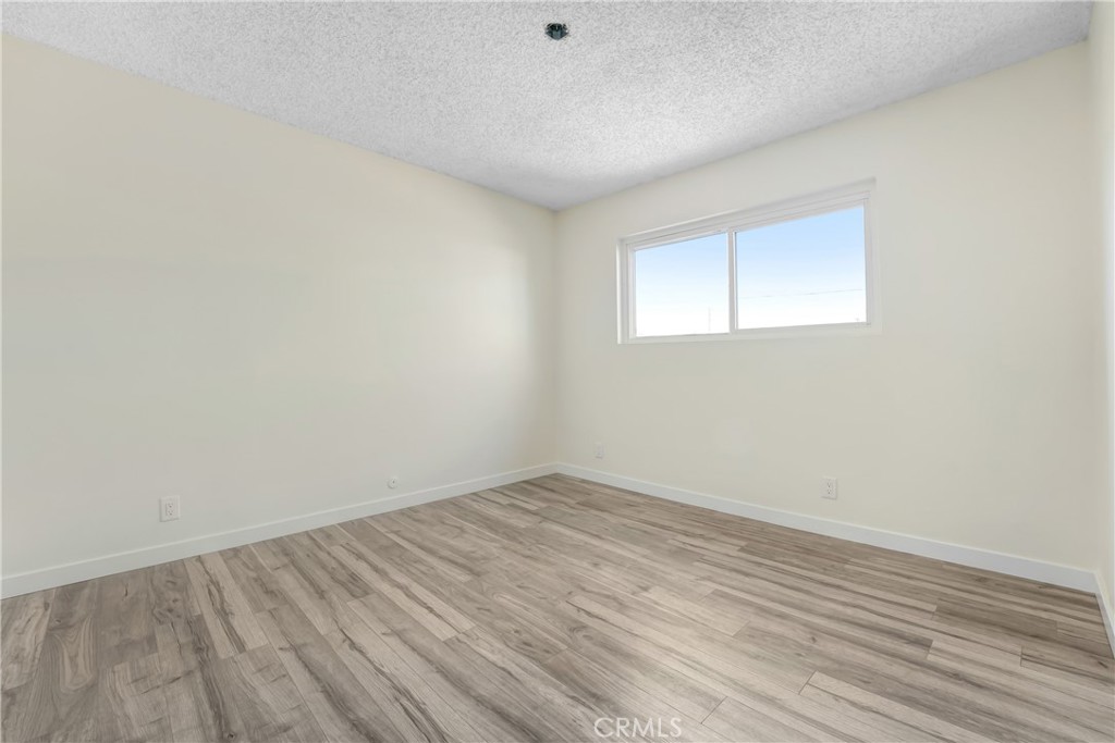 21323 Martin Street Carson, CA 90745 - Photo 16 of 21 an empty room with wooden floor and windows