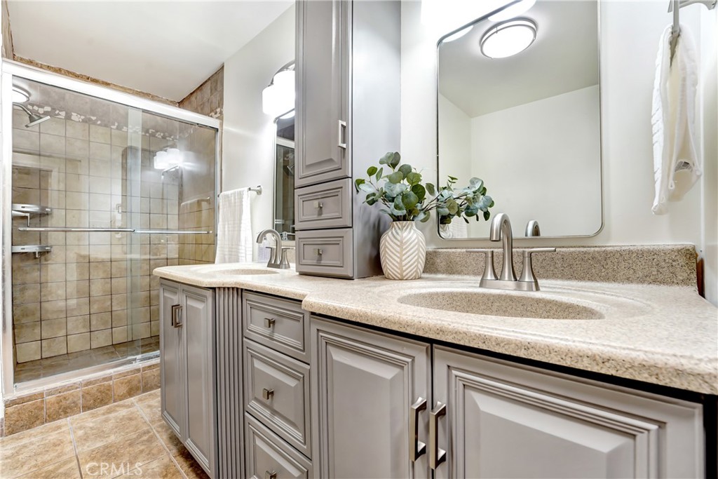 21323 Martin Street Carson, CA 90745 - Photo 9 of 21 a bathroom with a granite countertop sink a mirror and shower