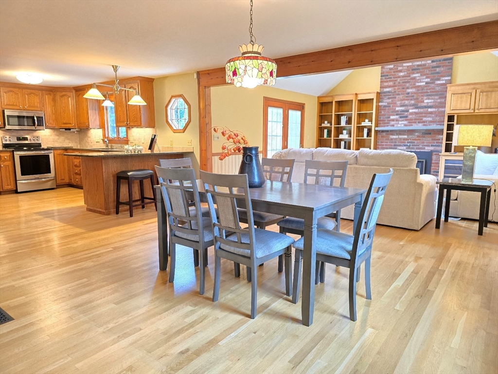 42 Wayside Lane Ashland, MA 01721 - Photo 15 of 40 a dining room with wooden floor a chandelier a wooden table and chairs