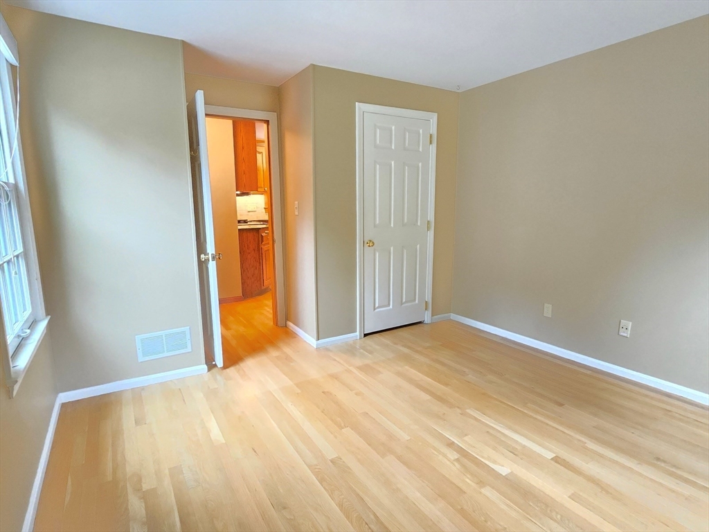 42 Wayside Lane Ashland, MA 01721 - Photo 29 of 40 a view of an empty room with wooden floor and a window
