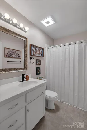 a bathroom with a granite countertop sink mirror vanity and toilet