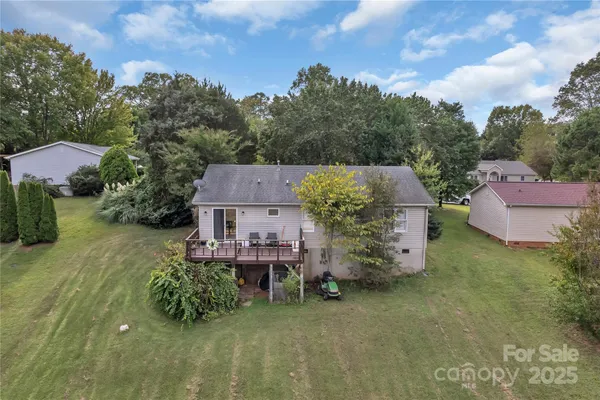 a view of wooden deck and lake with trees in the background